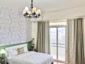 a bedroom with a bed and a large window at 永安101 Wing on x 附陽台 in Taitung City