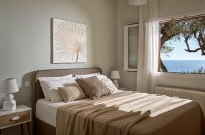 a bedroom with a bed with a view of the ocean at Villa Anatoli - Tranquil Escape with Scenic Views, by ZanteWize in Akrotiri