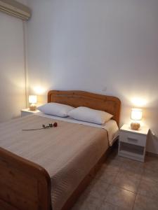 a bedroom with a bed with two lamps on it at Korali in Symi