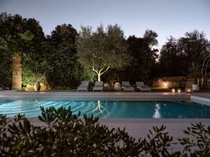 a swimming pool at night with chairs and trees at Villa Anatoli - Tranquil Escape with Scenic Views, by ZanteWize in Akrotiri +49 photos