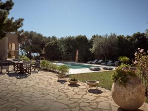 un patio con tavolo e sedie accanto alla piscina di Villa Anatoli ad Akrotiri