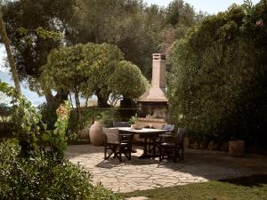 a patio with a table and chairs and a fireplace at Villa Anatoli - Tranquil Escape with Scenic Views, by ZanteWize in Akrotiri