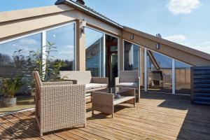 a patio with wicker chairs and tables on a deck at ⸨⸩ Sunset Penthouse: Messe - Siemens - DB - MAN ⸨⸩ in Nuremberg