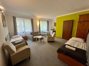 a bedroom with two beds and a living room at Gościniec Rospuda in Augustów