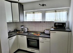 a kitchen with white cabinets and a stove top oven at black-forest holiday - Ferienresort am Schluchsee in Schluchsee