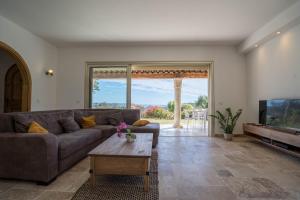 salon z kanapą i telewizorem w obiekcie VILLA L'ESTEREL AVEC PISCINE VUE MER 6 Pers w Fréjus