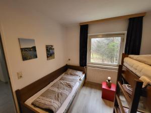 a small room with a bed and a window at black-forest holiday - Ferienresort am Schluchsee in Schluchsee