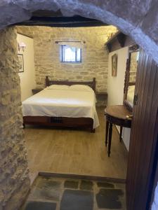 1 dormitorio con 1 cama y 1 mesa en una habitación en Konaku Guest house, en Gjirokastra