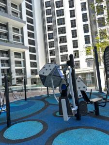 The Shore KK City Sabah Homestay في كوتا كينابالو: صالة ألعاب رياضية مع معدات ممارسة الرياضة أمام المبنى