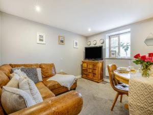 a living room with a couch and a table at Coed Y Gaer Annexe - Uk43776 in Llansilin