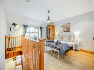 a bedroom with a bed and a staircase at Coed Y Gaer Annexe - Uk43776 in Llansilin