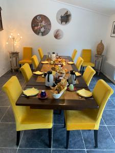 a dining room with a table and yellow chairs at Maison Castellane Chambre d'Hotes B&B in Castellane