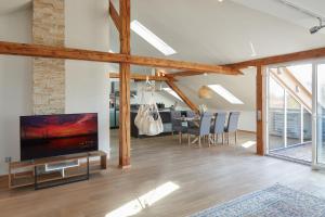 a living room with a large television and a dining room at ⸨⸩ Sunset Penthouse: Messe - Siemens - DB - MAN ⸨⸩ in Nuremberg