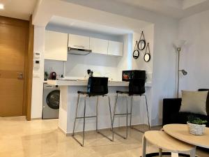 a kitchen with two bar stools in a living room at Yasmine Plaza CFC in Casablanca