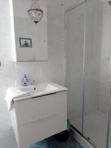a bathroom with a white sink and a shower at Da qui, il mare in Genova +6 photos
