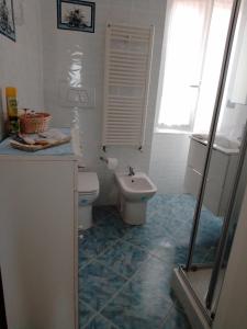uma casa de banho com um WC e um lavatório em Da qui, il mare em Gênova