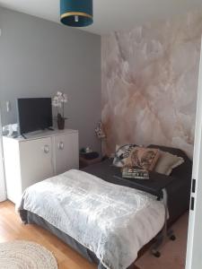 - une chambre avec un lit et un mur en marbre dans l'établissement Les Berges Impressionnistes 1 chambre avec terrasse, à Lagny-sur-Marne