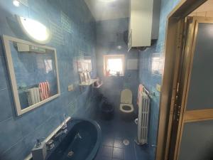 La salle de bains est pourvue de carrelage bleu, d'un lavabo et de toilettes. dans l'établissement Casa Amore, à Tarente 46 autres photos