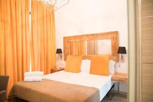 1 dormitorio con 1 cama grande y cortinas de color naranja en Doble S Rooms - Hostal, en Sevilla