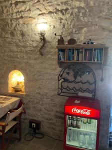 a coca cola refrigerator in a room with a table at Konaku Guest house in Gjirokastër