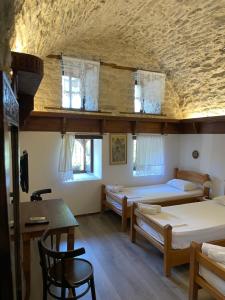 Habitación con 2 camas, mesa y sillas en Konaku Guest house, en Gjirokastra