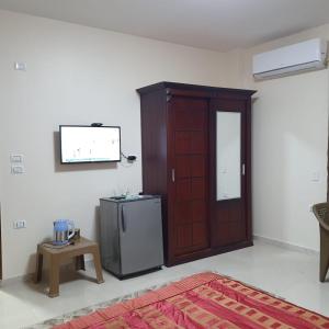 開羅的住宿－Andy Guest House，客房设有木门和冰箱。