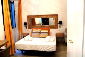 1 dormitorio con 1 cama con espejo en la pared en Doble S Rooms - Hostal en Sevilla
