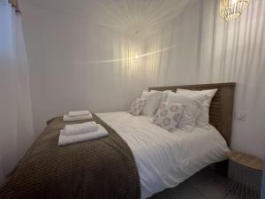 a bedroom with a bed with white sheets and pillows at Superbe T2 vue mer, clim, parking gratuit in Canet-en-Roussillon