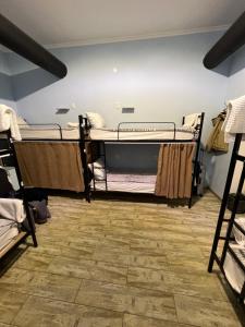 a room with three bunk beds and a wooden floor at Tbil Home Hostel in Tbilisi City
