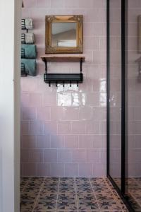 een badkamer met een spiegel op een roze tegelmuur bij Boutique B&B Dolce Due in Assendelft +38 foto's