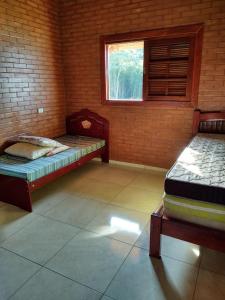 a room with two beds and a window at Chácara Buscapé in Mogi das Cruzes