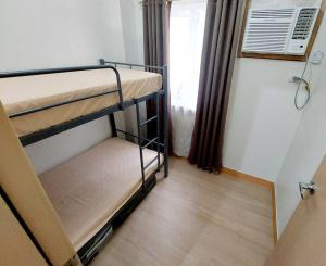 Habitación pequeña con 2 literas y ventana en 2-bedroom condo unit with Netflix and board games, en Manila