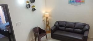 a living room with a leather couch and a chair at Beach Dreamz Villa 2 BHK Near Pondy and Auroville in Marakkānam