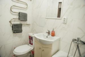 Un baño blanco con inodoro y lavabo. en Затишна квартира в центрі, ближче до Софіївського парку., en Uman