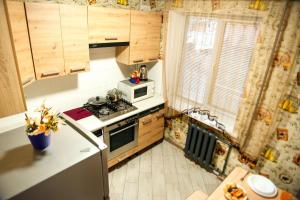 Una pequeña cocina con estufa y microondas. en Затишна квартира в центрі, ближче до Софіївського парку., en Uman 6 fotos más