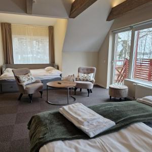 1 dormitorio con 2 camas y 2 sillas en Toftastrand Hotell, en Växjö