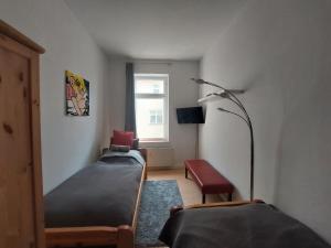 a bedroom with two beds and a lamp and a window at Schöne Zwei-Zimmer-Wohnung "W2" mit 4 Einzelbetten und WLAN in Zwenkau bei Leipzig im Neuseenland in Zwenkau