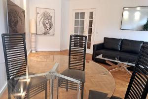 a living room with a glass table and a couch at Appartement aux Portes de Paris et 5 minutes du métro in Charenton-le-Pont