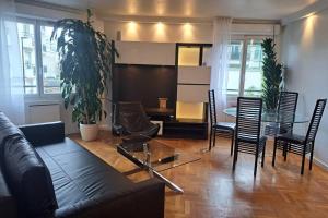 a living room with a couch and a table and chairs at Appartement aux Portes de Paris et 5 minutes du métro in Charenton-le-Pont