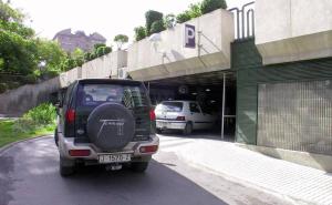 un SUV parcheggiato di fronte a un parcheggio di Apartamento Centro de Jaén a Jaén