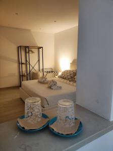 1 dormitorio con 1 cama con 2 sombreros y espejo en Miro B&B, en Lecce