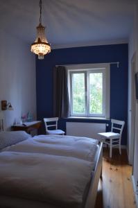 a blue bedroom with two beds and a window at Burger Fährhaus in Burgerfeld
