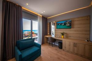 Habitación con silla, escritorio y ventana en Azure Inn Hotel, en Sarandë