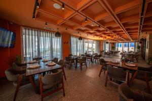 un restaurante con mesas y sillas en una habitación en Azure Inn Hotel, en Sarandë