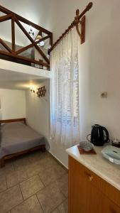 1 dormitorio con 1 cama y ventana en una habitación en Ano Syros Vibes en Syros