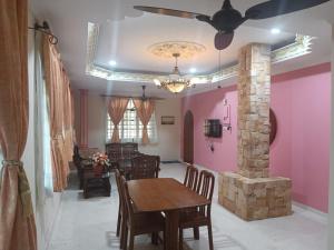 une salle à manger avec une table et une cheminée dans l'établissement BUTIK VILLA, à Port Dickson