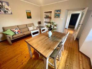 sala de estar con mesa de madera y sofá en Apartment Bianca with private garden, en Cossogno