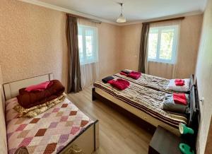 - une chambre avec 2 lits et 2 fenêtres dans l'établissement My home udabno, à Udabno