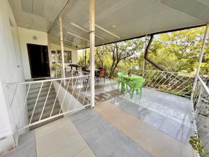 un porche vacío con mesa verde y sillas en My home udabno, en Udabno