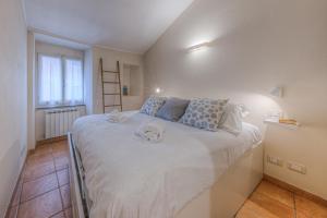 a bedroom with a large white bed with blue pillows at Oro by PortofinoHomes in Rapallo